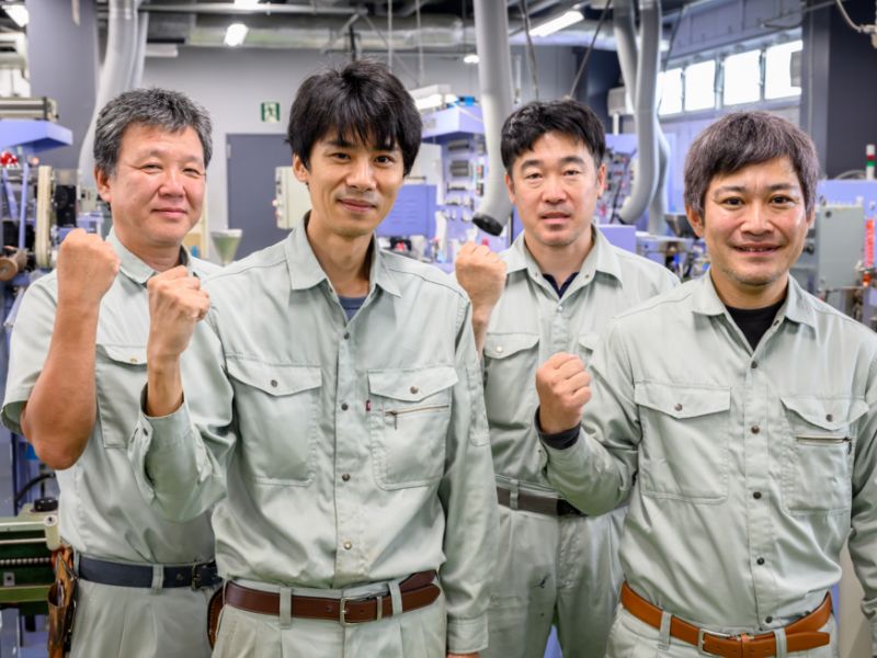 ガッツポーズをする社員たち